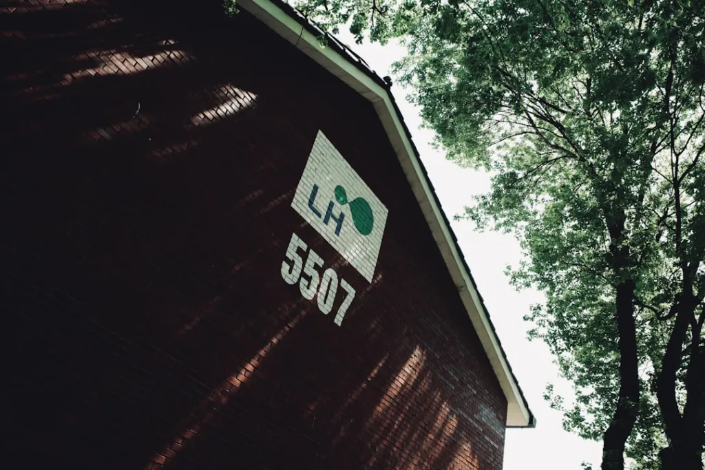 A picture of a barn with trees in the background
