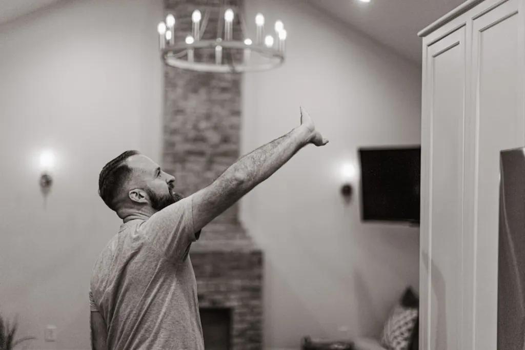 A man standing in a living room next to a fire place
