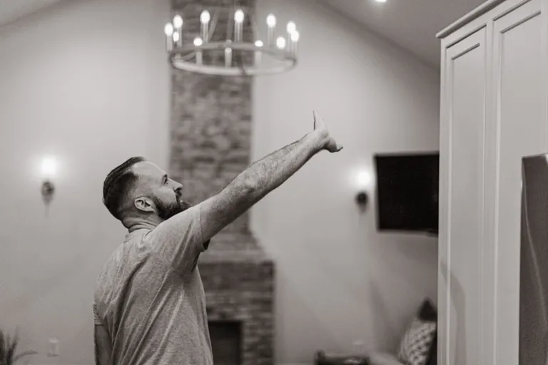 A man standing in a living room next to a fire place